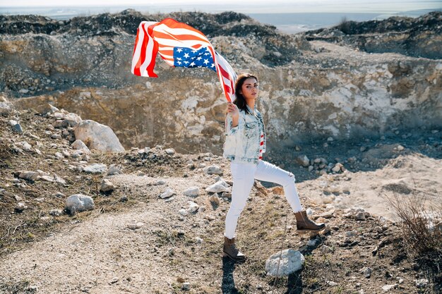 Mujer con bandera de Estados Unidos mirando a cámara