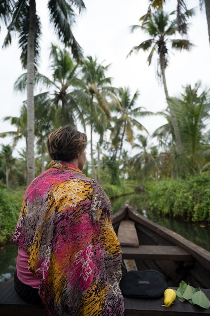 Foto gratuita mujer en un barco en un río tropical