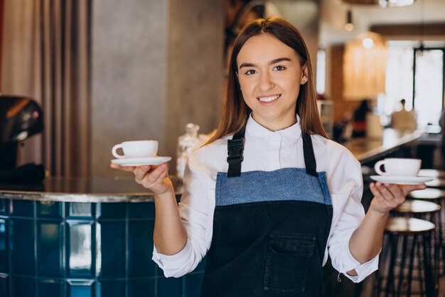 Mujer barista en la cafetería con espresso