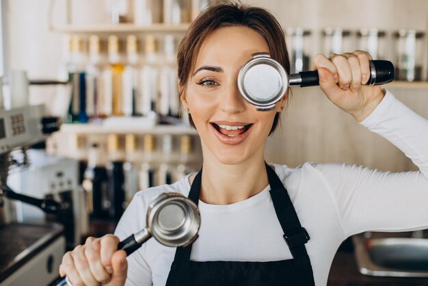 Mujer barista en una cafetería preparando café