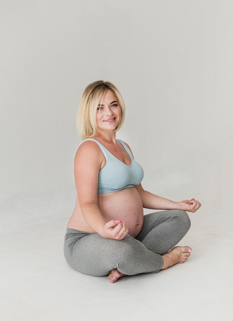 Mujer bastante embarazada meditando