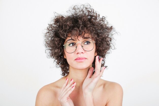 Mujer bastante joven con las lentes contra el contexto blanco