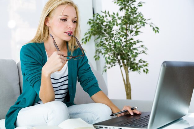 Mujer bastante joven que trabaja con la computadora portátil en el país.