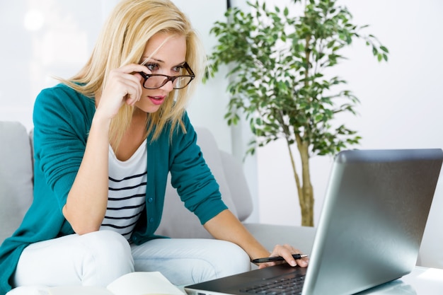 Mujer bastante joven que trabaja con la computadora portátil en el país.