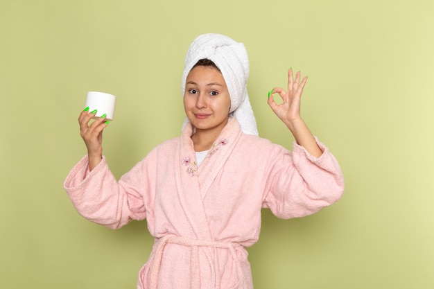 Foto gratuita mujer en bata de baño rosa con crema para la cara