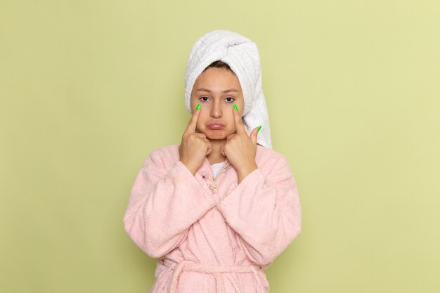 mujer en bata de baño rosa posando con expresión triste