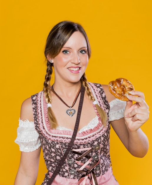 Mujer bávara sonriente con pretzel
