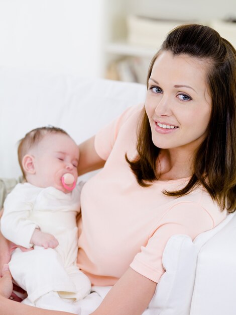 Mujer con bebé durmiendo en sus manos