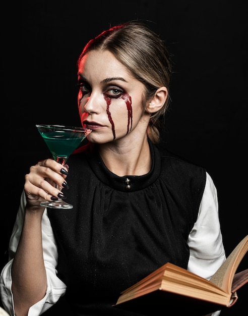 Mujer con bebida verde y libro