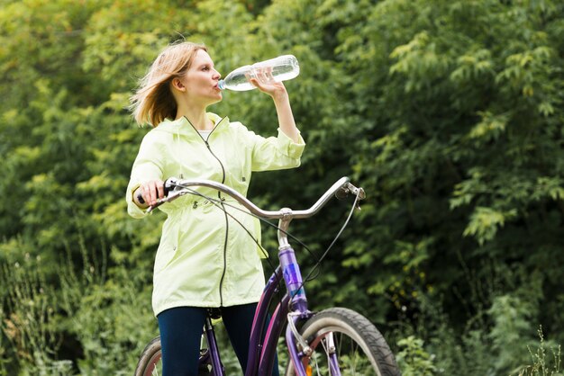 Mujer bebiendo agua en bicicleta