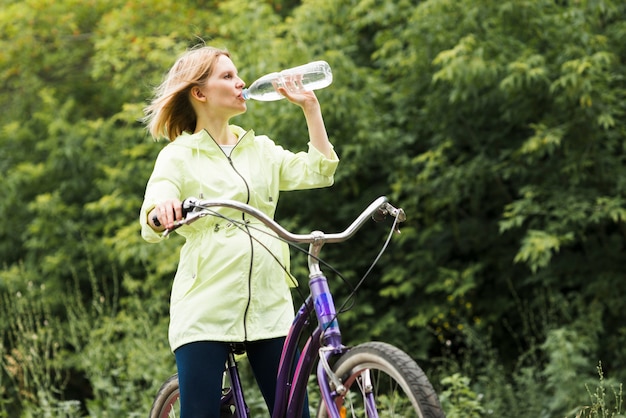 Mujer bebiendo agua en bicicleta