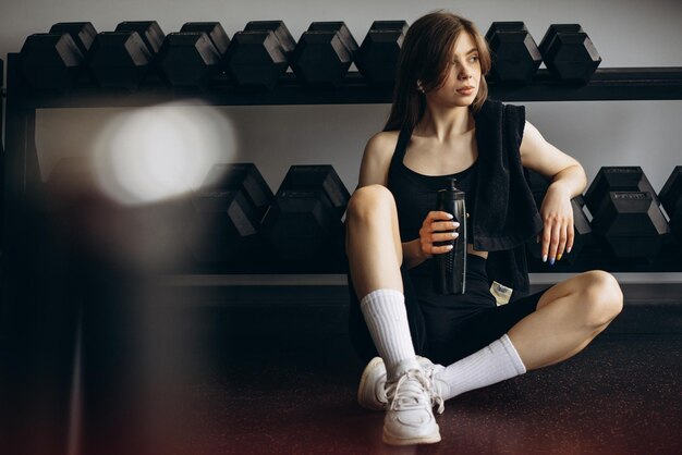 Mujer bebiendo agua en el gimnasio