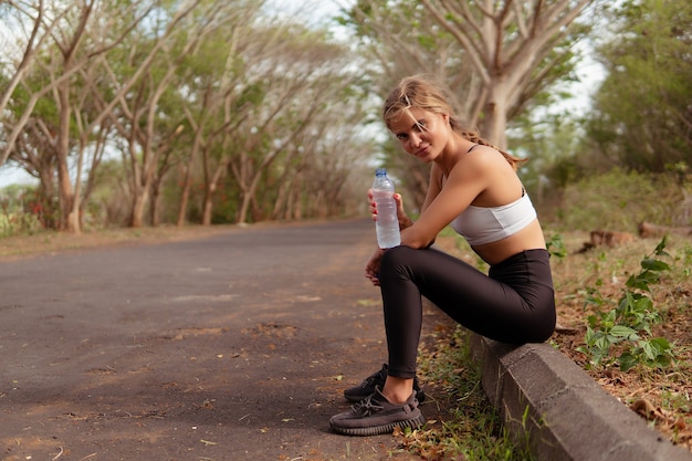 Mujer bebiendo agua en el parque. bali