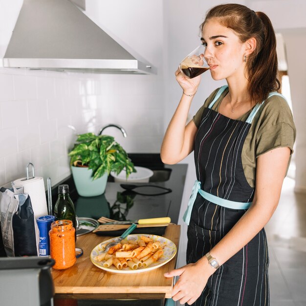 Mujer bebiendo café negro en la cocina