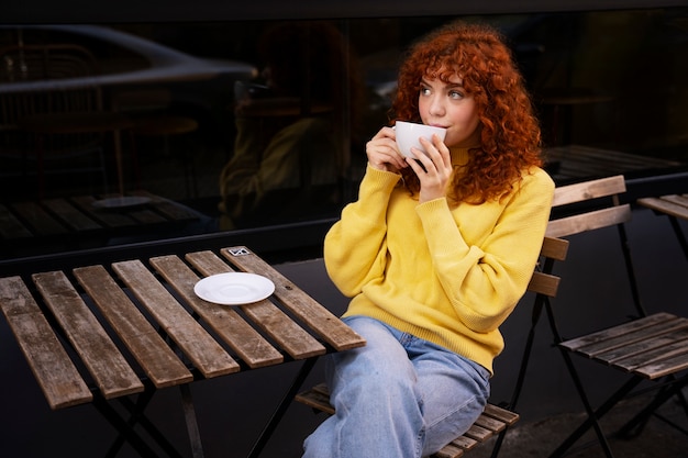 Foto gratuita mujer bebiendo chocolate caliente en el cafe