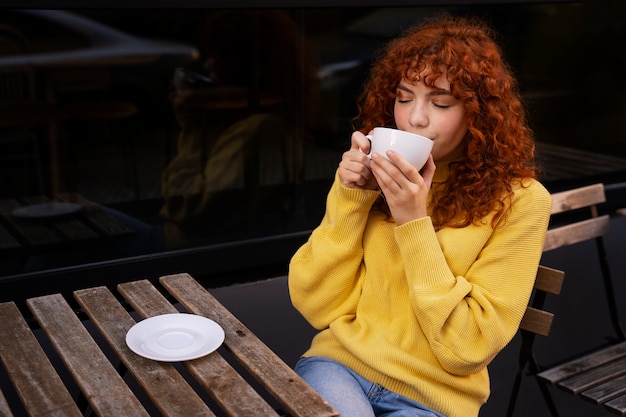 Foto gratuita mujer bebiendo chocolate caliente en el cafe