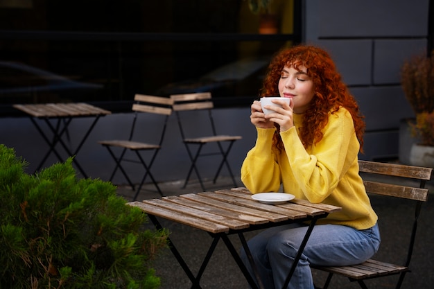 Foto gratuita mujer bebiendo chocolate caliente en el cafe