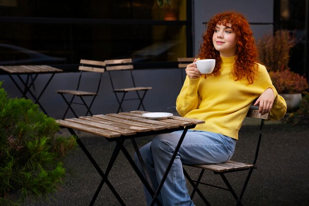 Mujer bebiendo chocolate caliente en el cafe