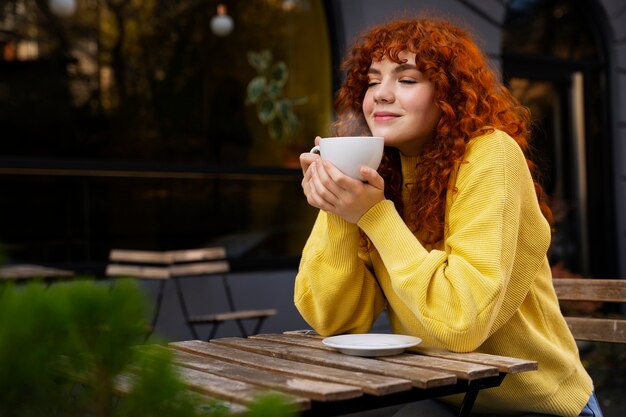 Mujer bebiendo chocolate caliente en el cafe