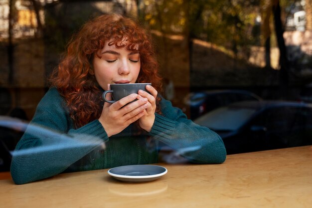 Mujer bebiendo chocolate caliente en el cafe