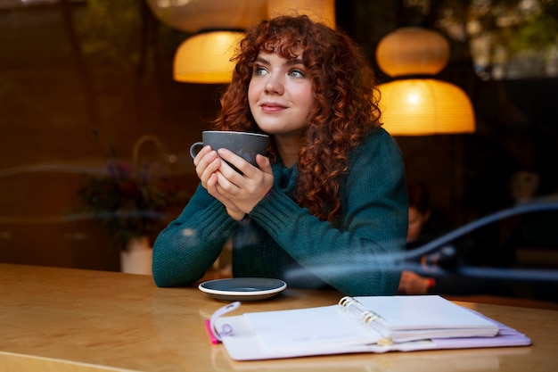 Mujer bebiendo chocolate caliente en el cafe