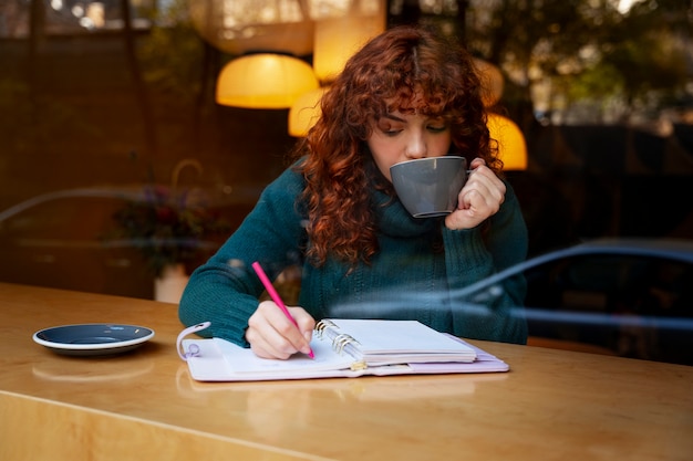 Mujer bebiendo chocolate caliente en el cafe