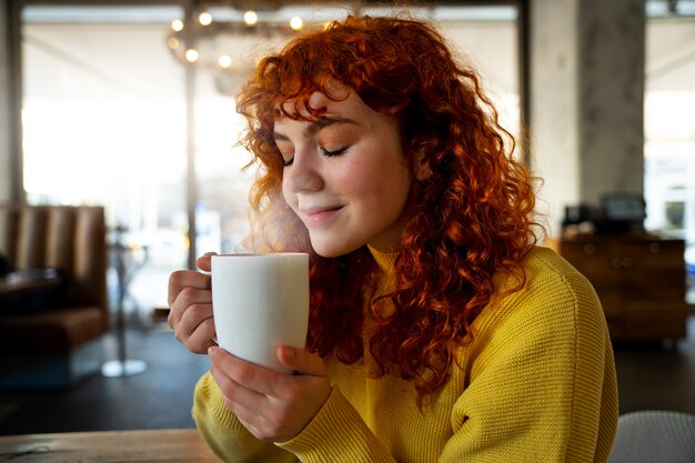 Mujer bebiendo chocolate caliente en el cafe