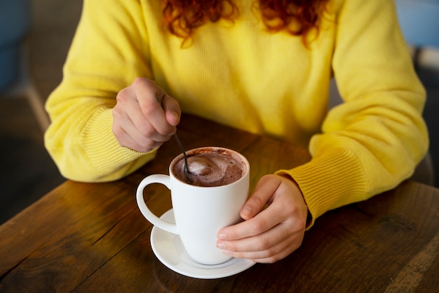 Mujer bebiendo chocolate caliente en el cafe