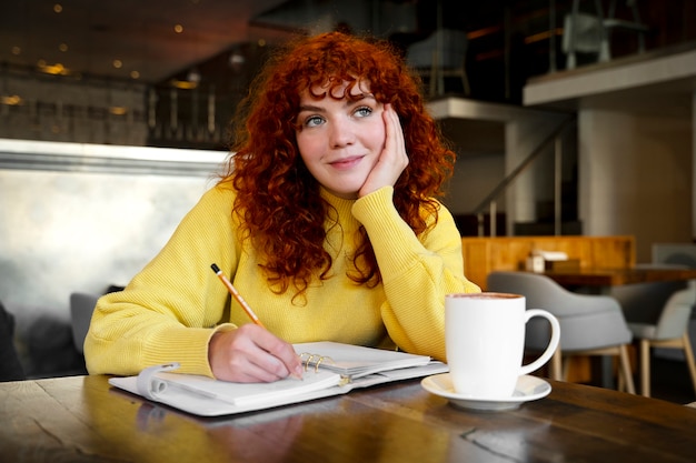 Foto gratuita mujer bebiendo chocolate caliente en el cafe