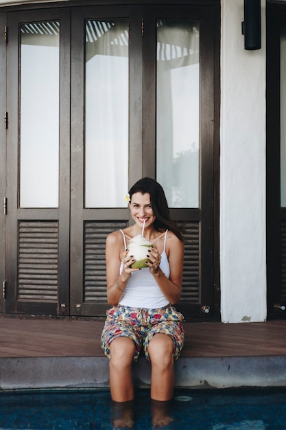 Mujer bebiendo un coco fresco