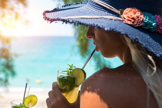 Mujer bebiendo cócteles en el bar de la playa