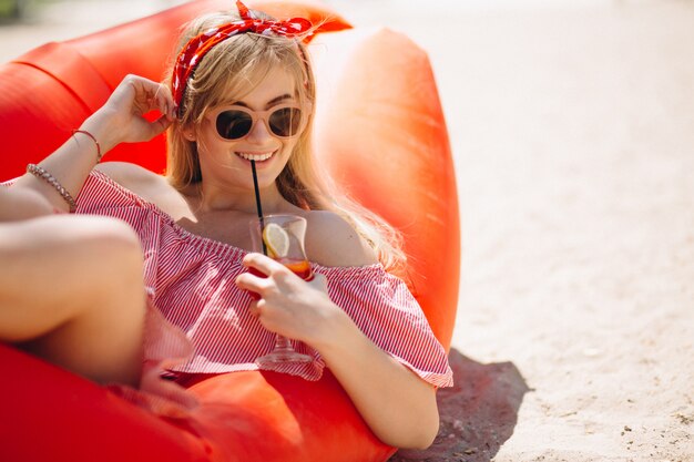 Mujer bebiendo cócteles en la playa