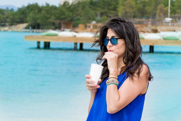 Mujer bebiendo con gafas de sol