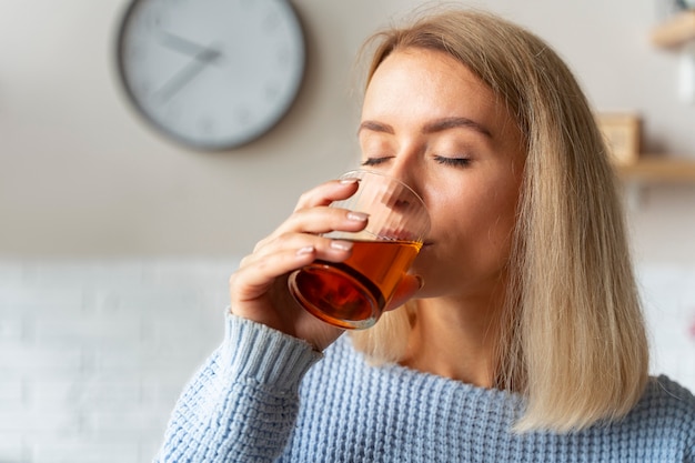 Mujer bebiendo kombucha vista lateral