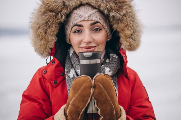 Mujer bebiendo té caliente en invierno afuera
