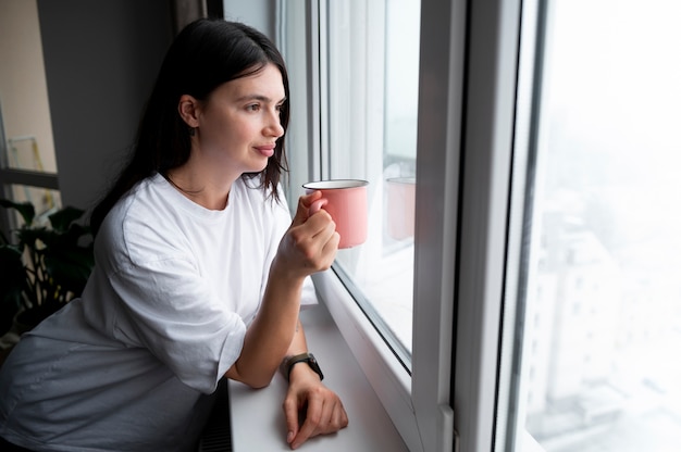 Mujer bebiendo té en casa durante la cuarentena