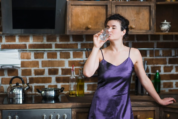 Mujer bebiendo té en la cocina