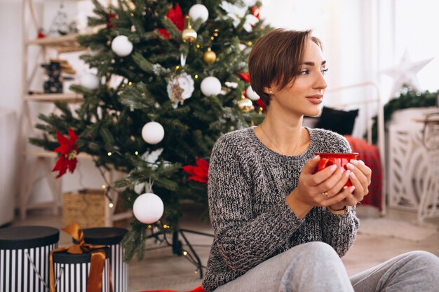 Mujer bebiendo té en la víspera de Navidad