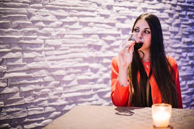 Mujer bebiendo vino en el restaurante