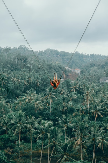 Mujer de belleza en columpio, naturaleza de Bali, cara feliz, selva