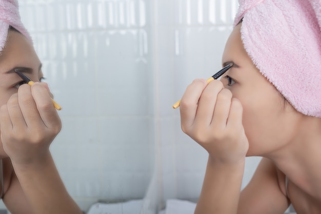 Mujer de la belleza que aplica maquillaje.