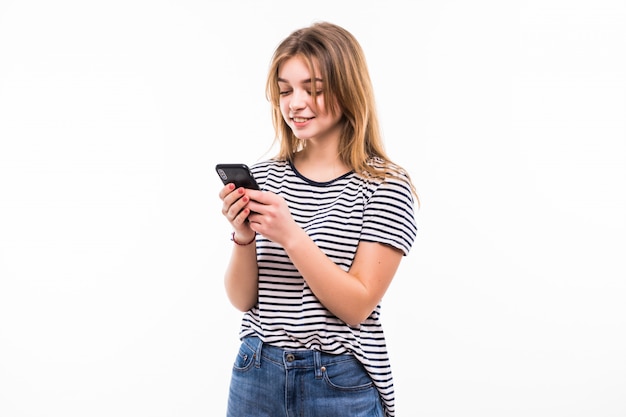 Mujer de belleza usando y leyendo un teléfono inteligente aislado en una pared blanca