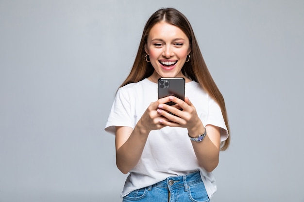 Mujer de belleza usando y leyendo un teléfono inteligente aislado