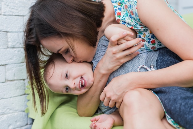 Mujer besando la mejilla de su hijo