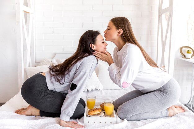 Mujer besando a la novia en la frente