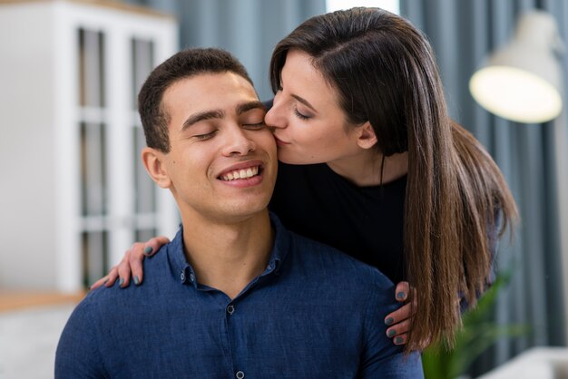 Mujer besando a su marido en el primer plano de la mejilla
