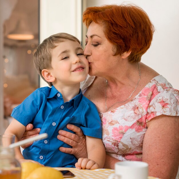 Mujer besando a su nieto en la mejilla