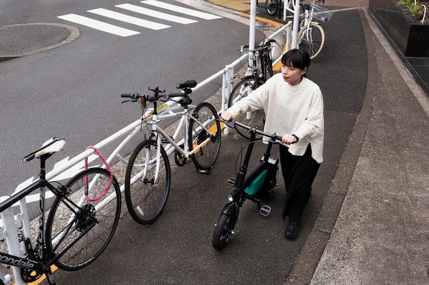 Mujer con bicicleta eléctrica en la ciudad