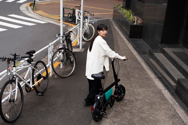 Mujer con bicicleta eléctrica en la ciudad