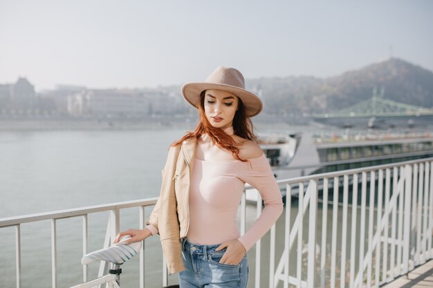 Mujer bien formada en traje rosa de pie en la naturaleza